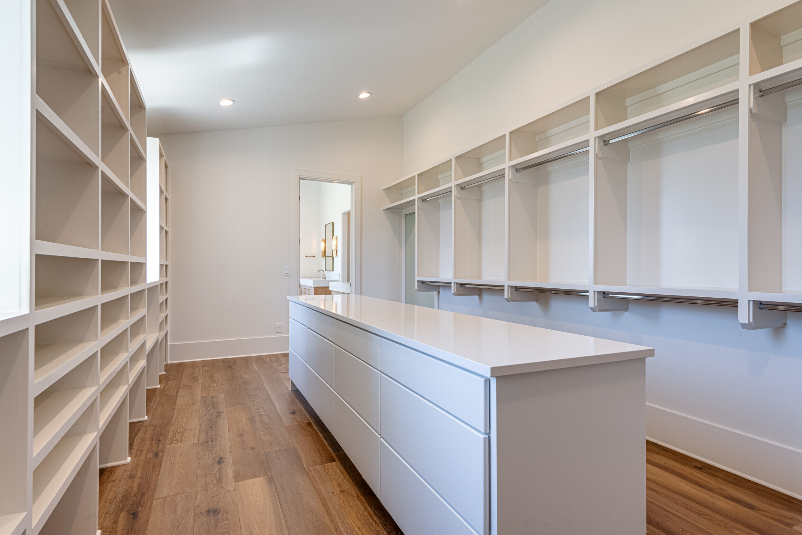 Large white walk-in closet with open shelving and a center island