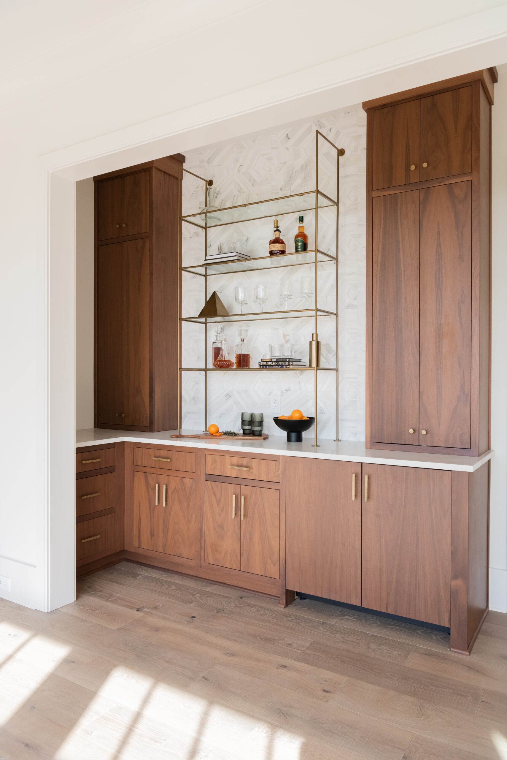 Double tower wood cabinetry with gold and glass bar shelving