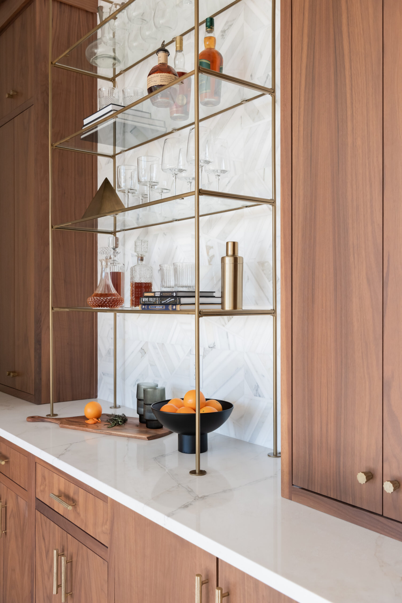 Double tower wood cabinetry with gold and glass bar shelving