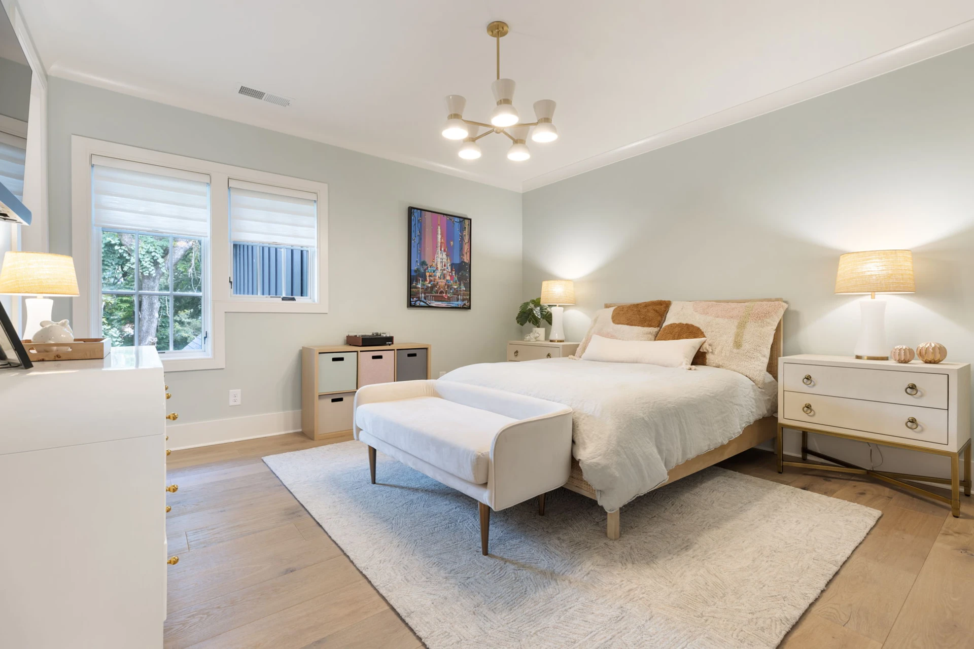 Bedroom with sage green walls, wood bed, sputnik chandelier, and an upholstered bench