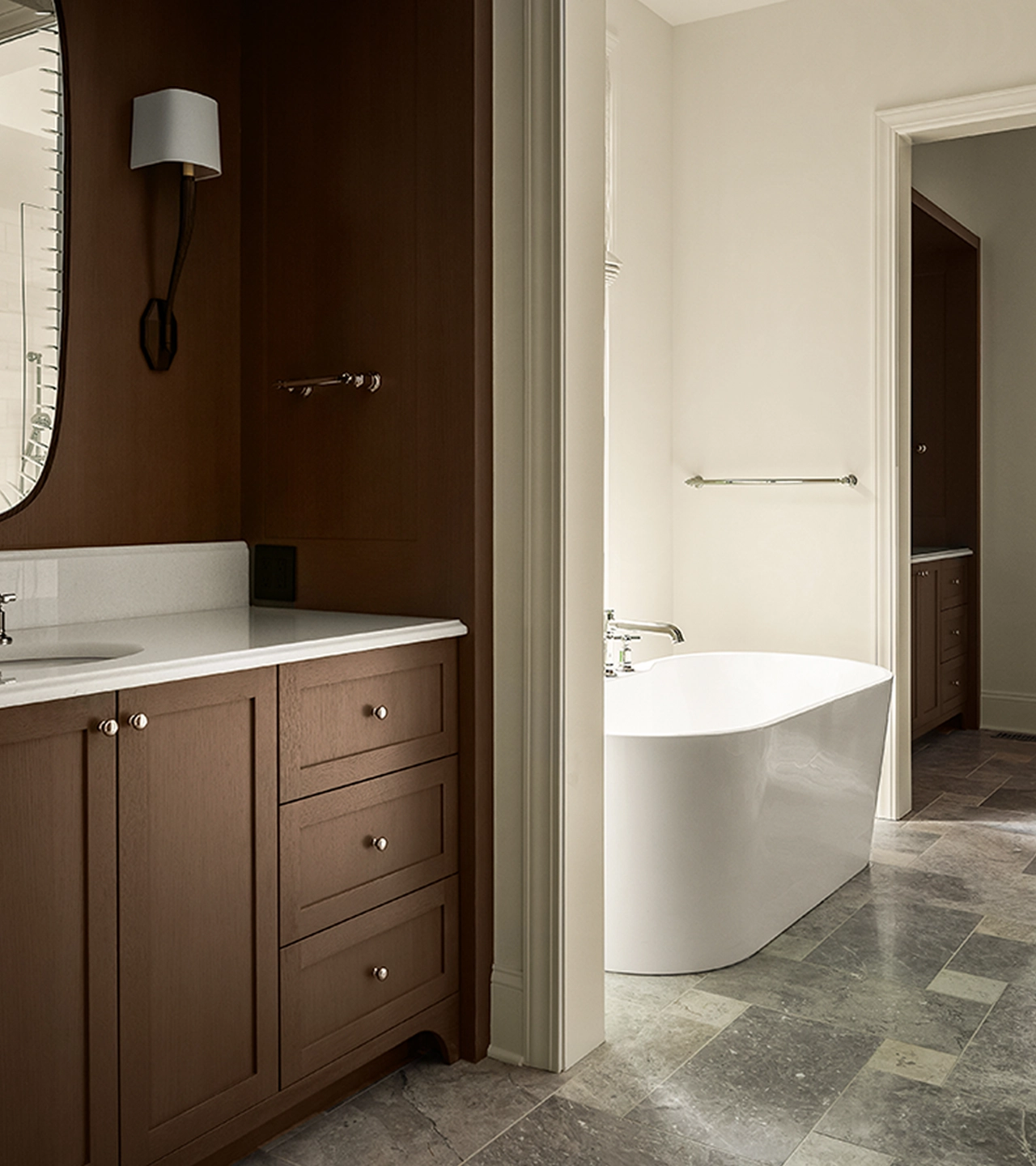 Bathroom with brown cabinetry, a freestanding tub, and tile flooring