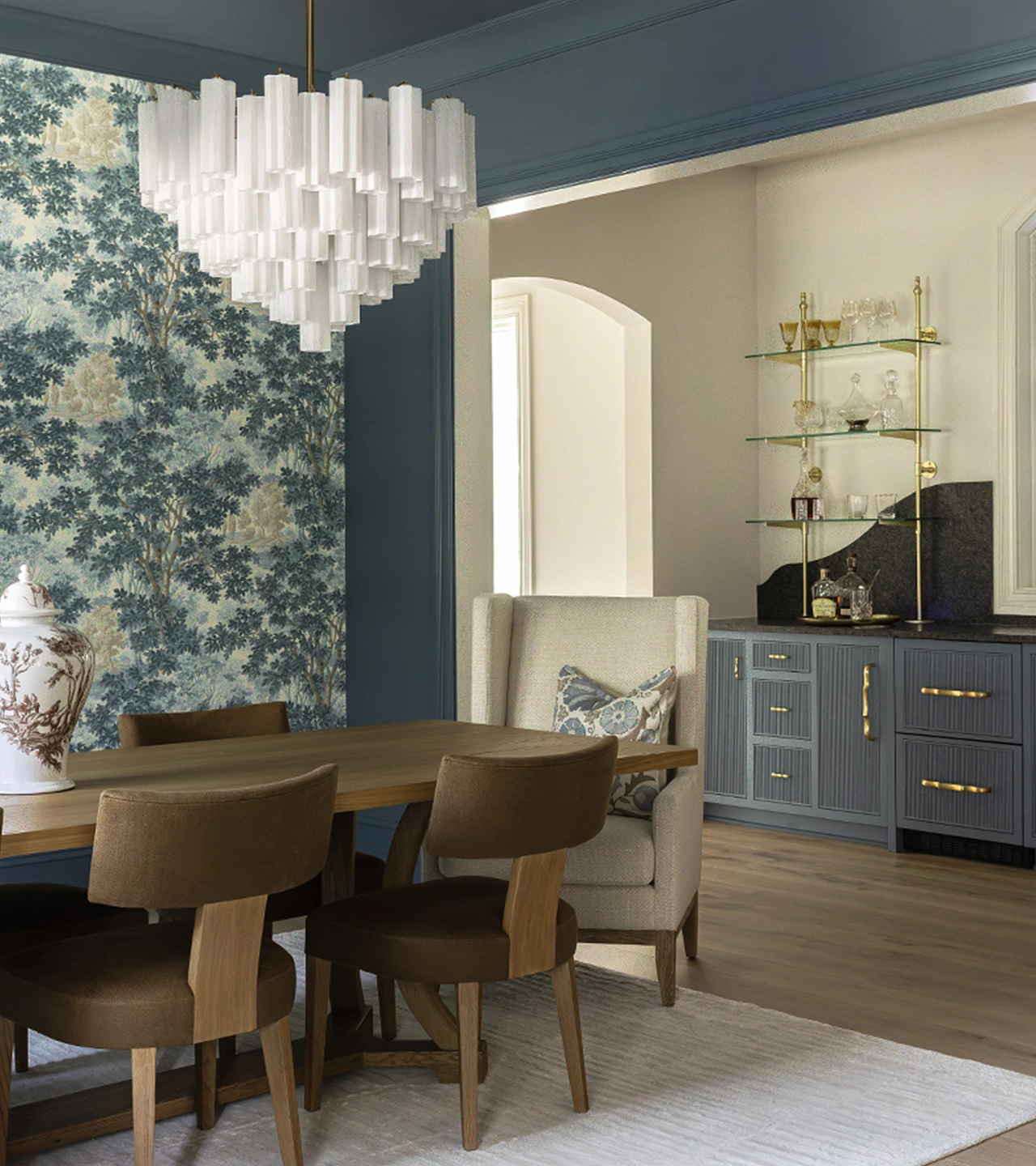 Dining room with brown table and seating, a bar, an accent patterned wall, and a tiered chandelier