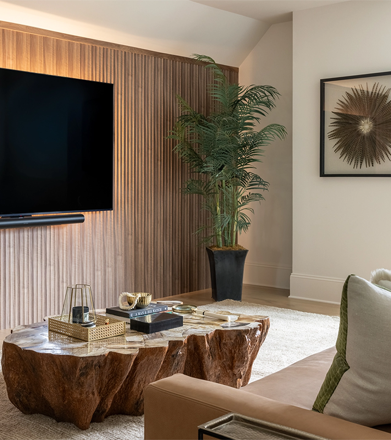 A seating area with rustic wooden coffee table, paneled wood accent wall, and a large plant in the corner