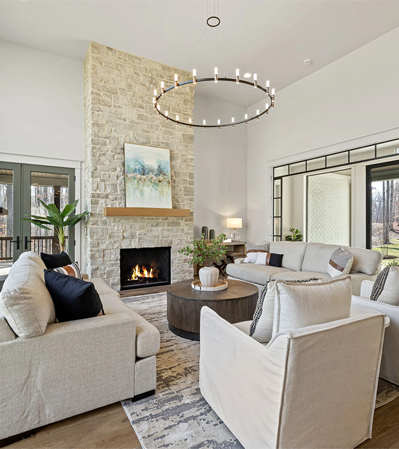 A family room with floor to ceiling stone fireplace and large couches