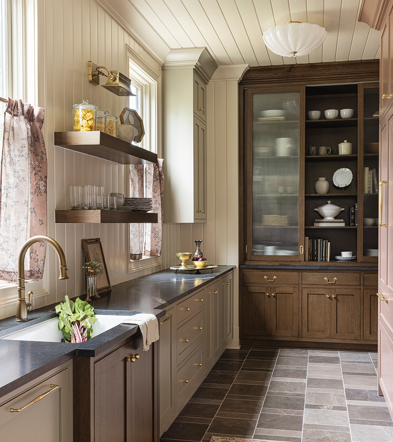 Pantry with floor to ceiling shelving bookcase, earth-toned cabinetry and walls, and floating shelves about the sink