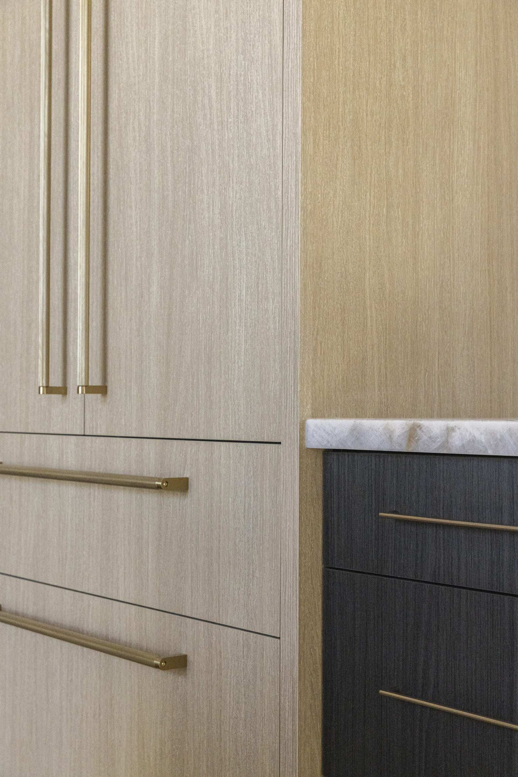 Light natural wood stained refrigerator door with oversized brushed gold door and drawer pulls