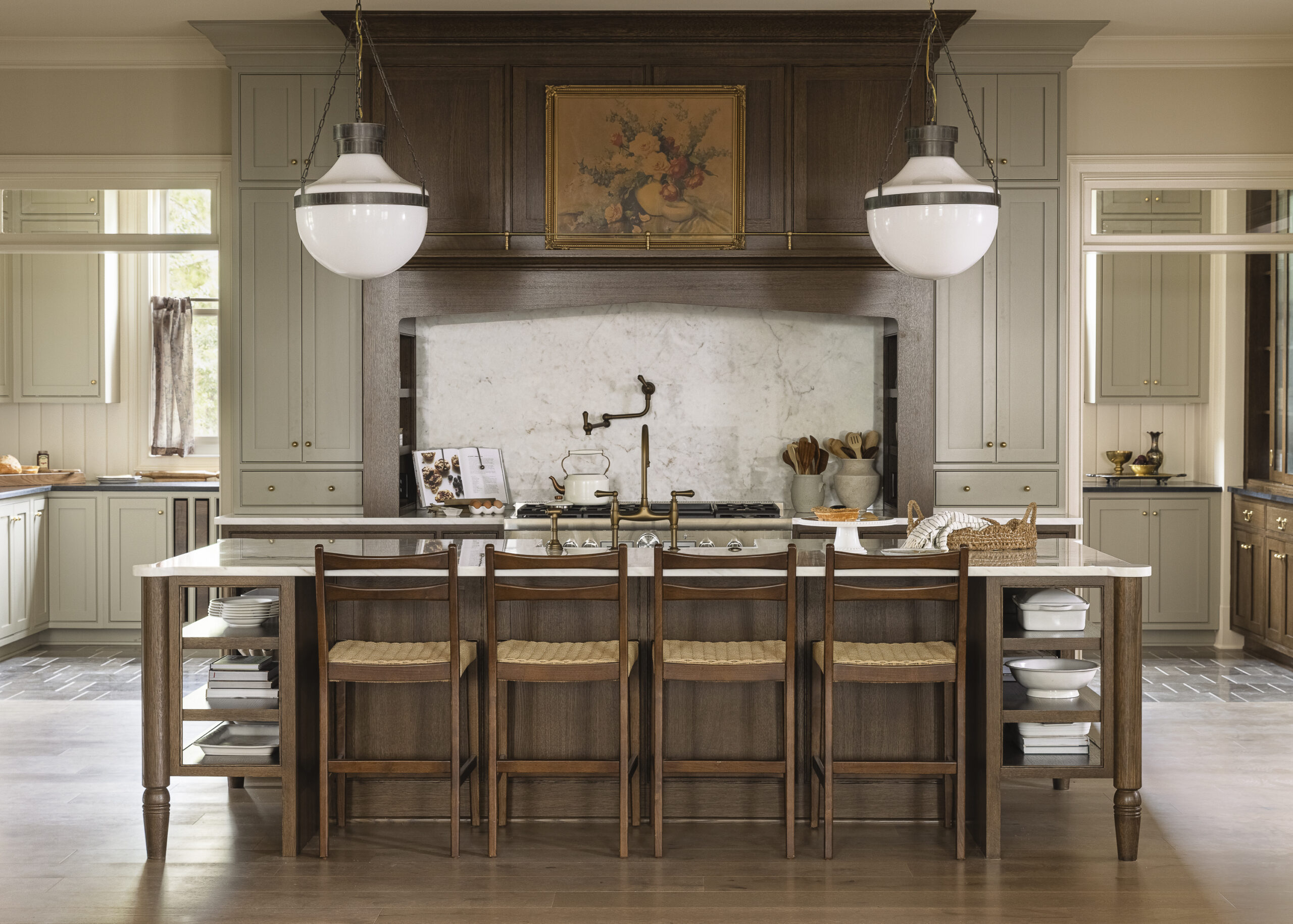 Kitchen with dark wood cabinetry, range hood, and island with white glass pendant