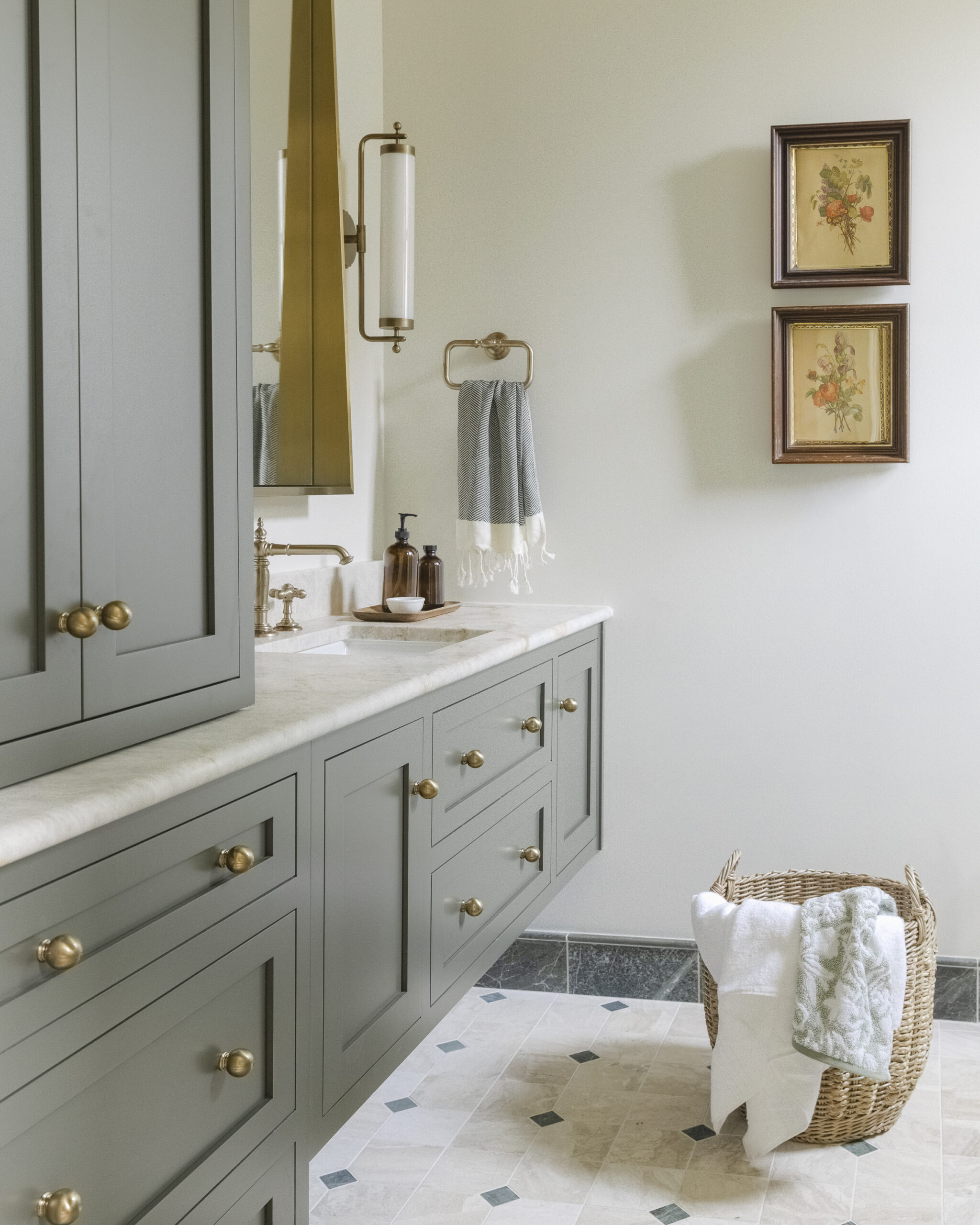 Muted green floating vanity and tan patterned tile and brushed gold mirror with white glass sconces