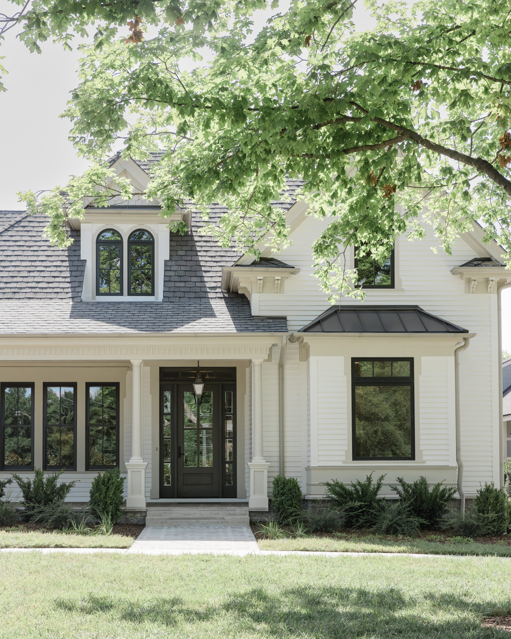 Victorian style home with white siding and a large wrap around porch
