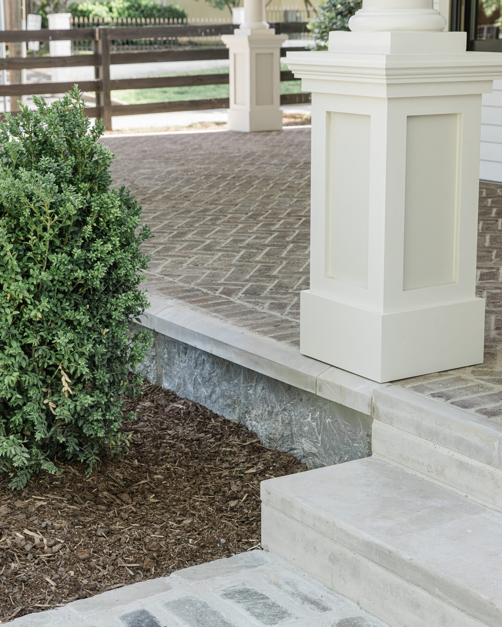 Front porch details featuring brick pavers and a stone fountdation
