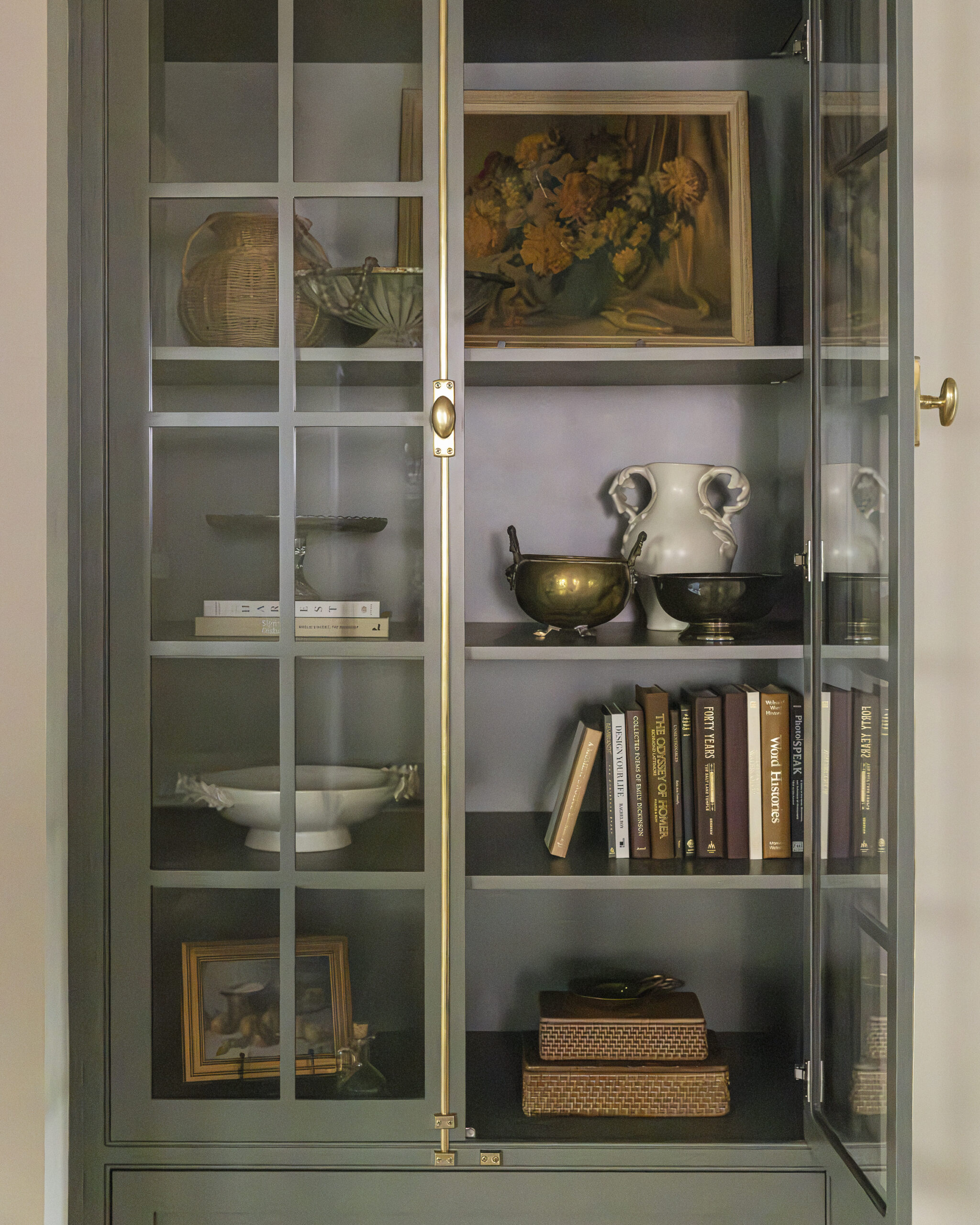 Sage green builtin cabinetry with glass paneled front