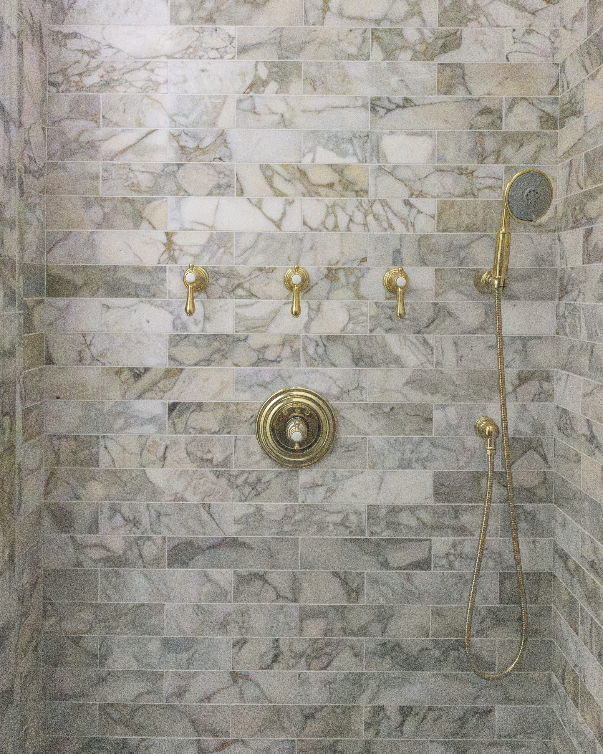 Marble shower with brushed gold shower fixtures