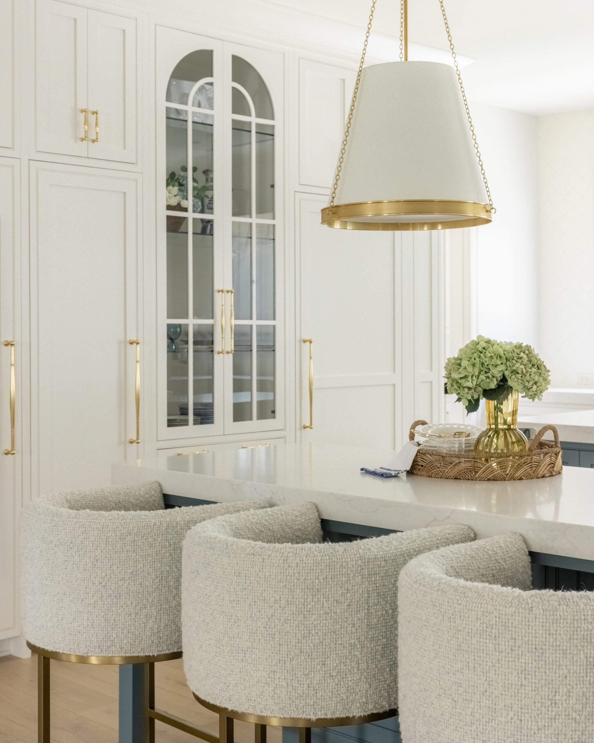 Kitchen view of white cabinets with a glass front pantry cabinet