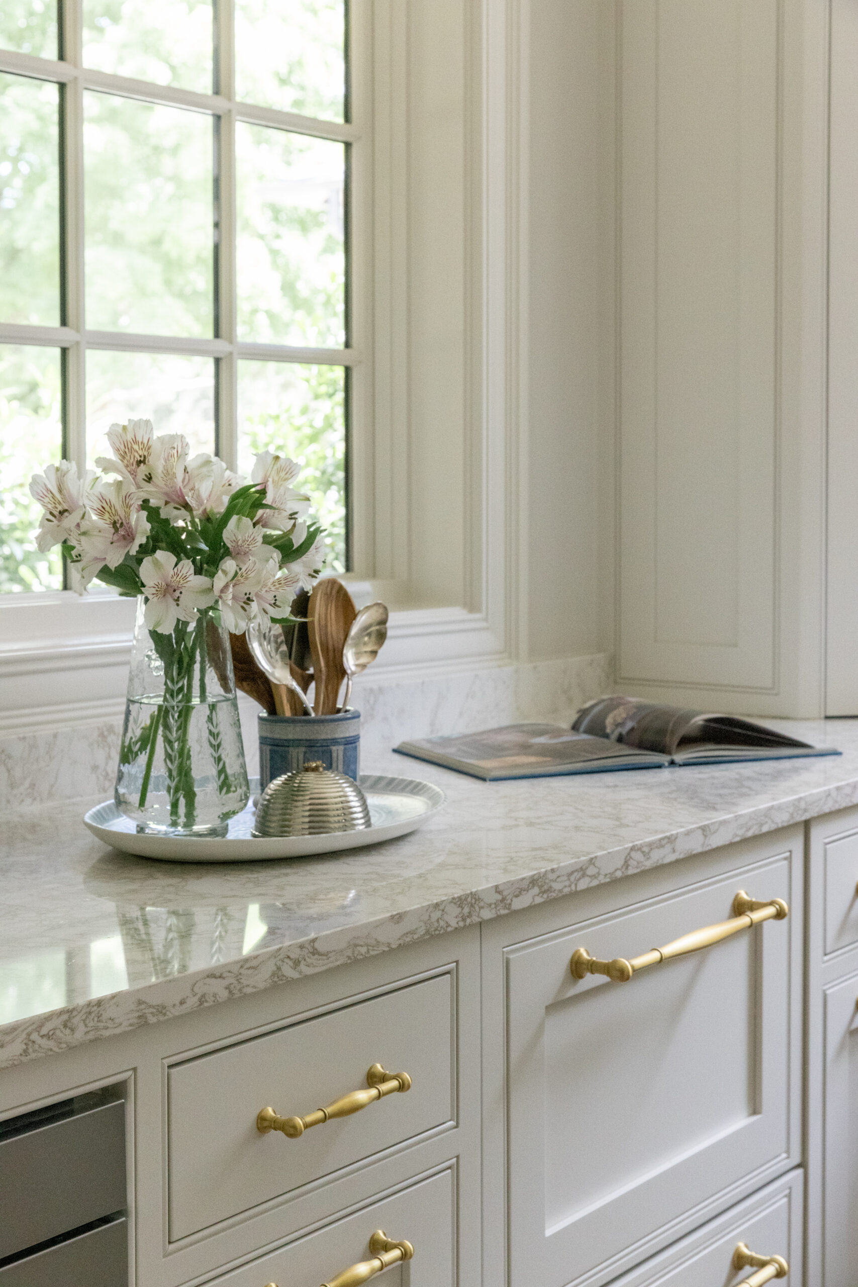 Pantry with white walls and cabinetry and countertops with a window and pantry cabinet