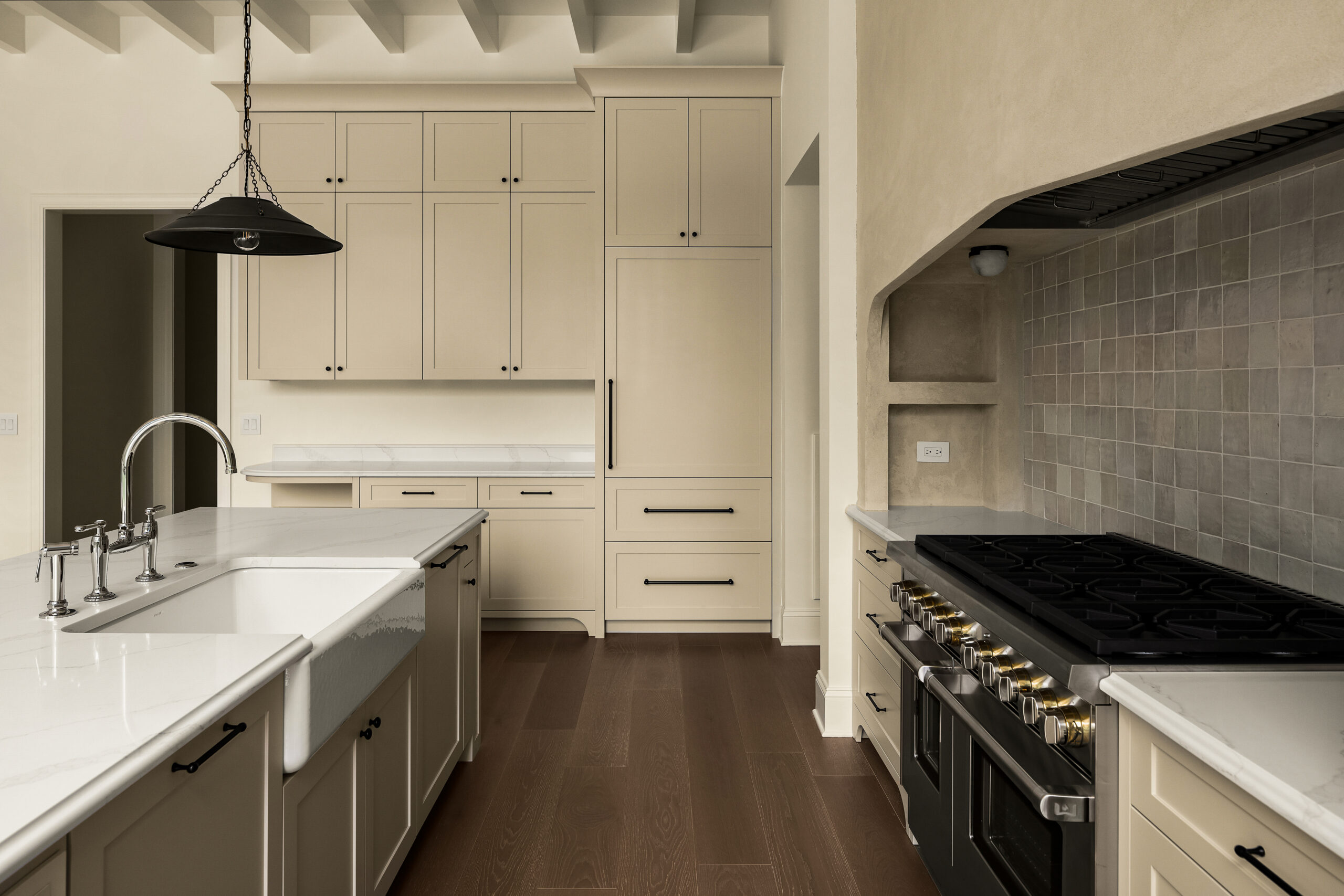 Beige cabinets with range and arched beige oversizedhood