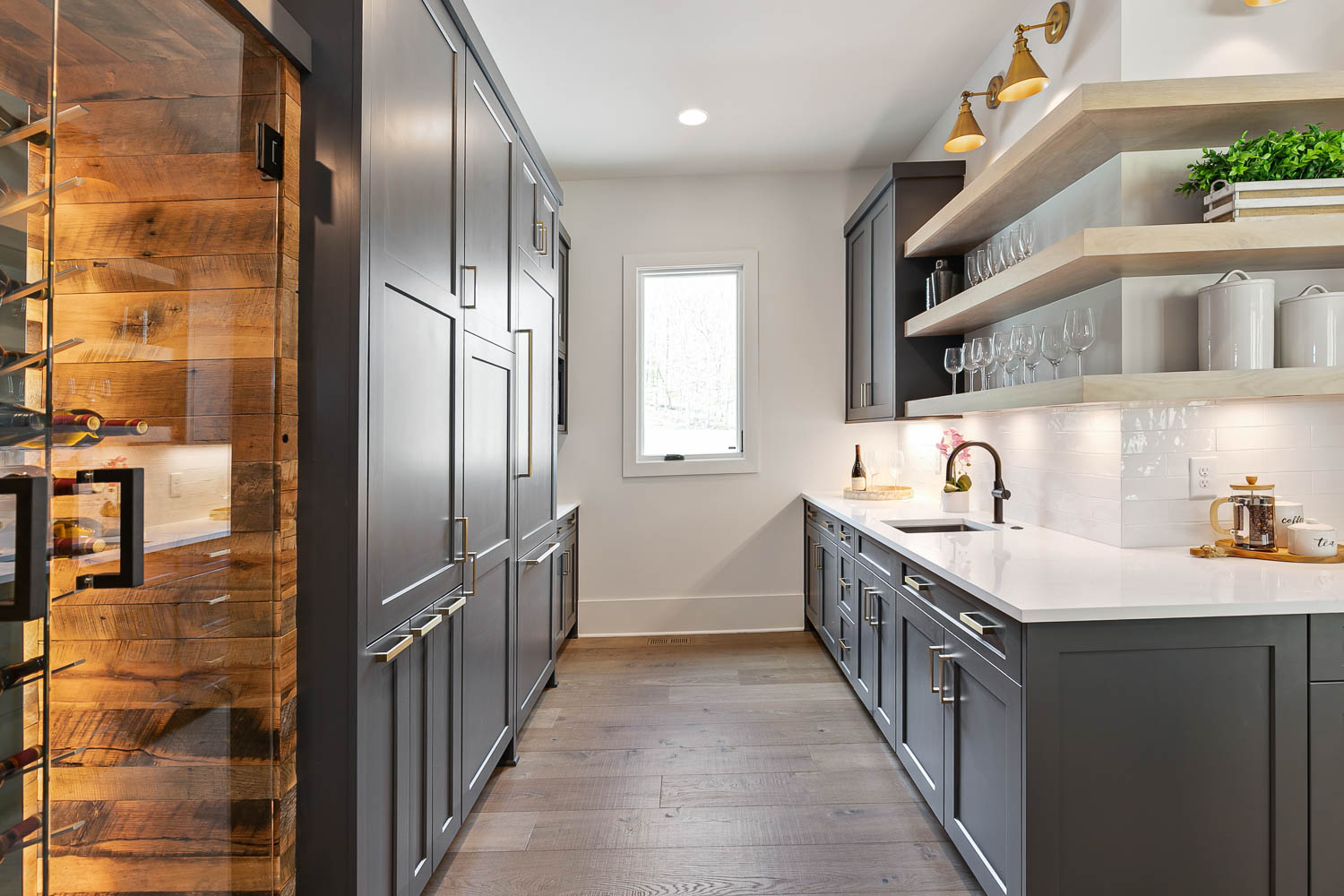 Navy cabinetry with light wood stained open shelving, with white countertops and backsplash