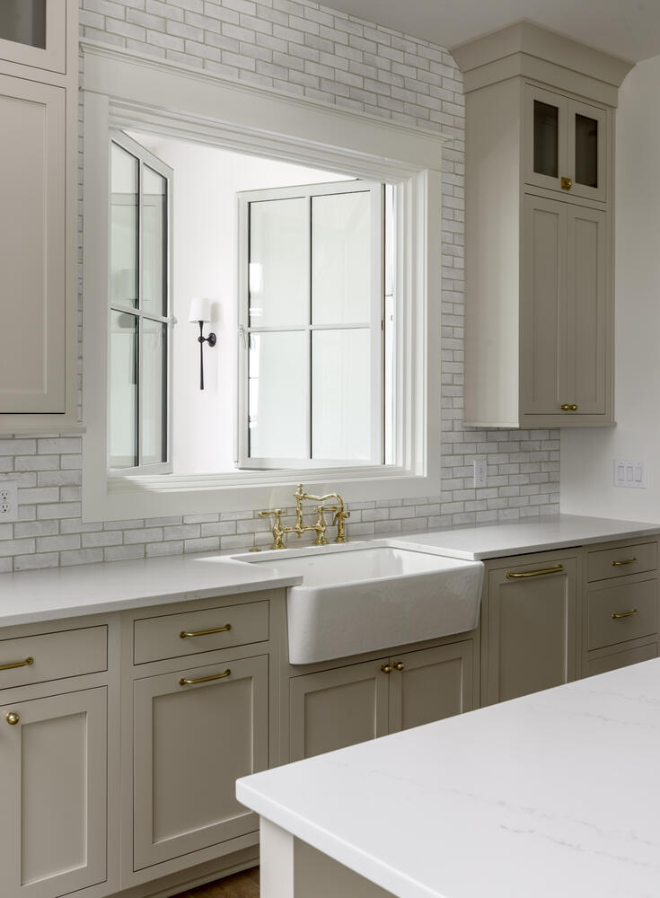 Beige kitchen cabinets with interior window over the sink