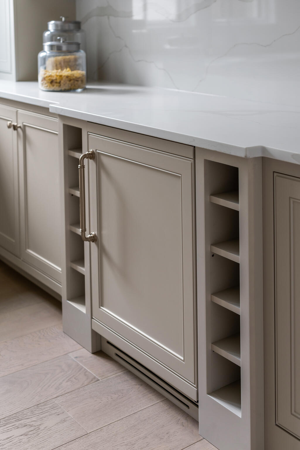 Beige cabinetry with white walls, backsplash, and countertops, windows, and beverage cooler
