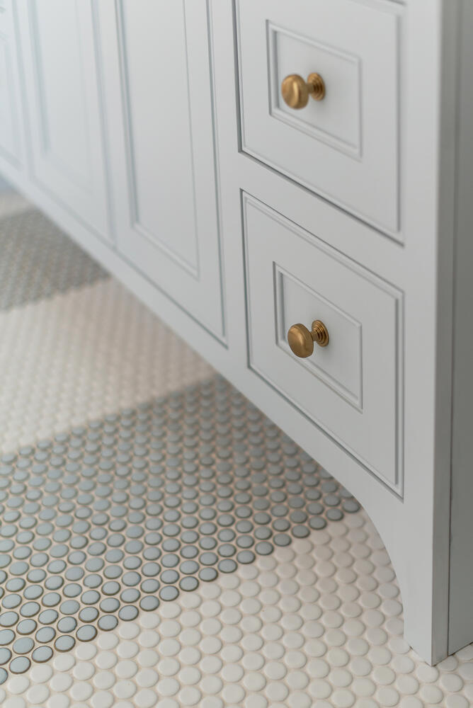 Striped blue and white penny tile with light gray vanity and gold drawer pulls