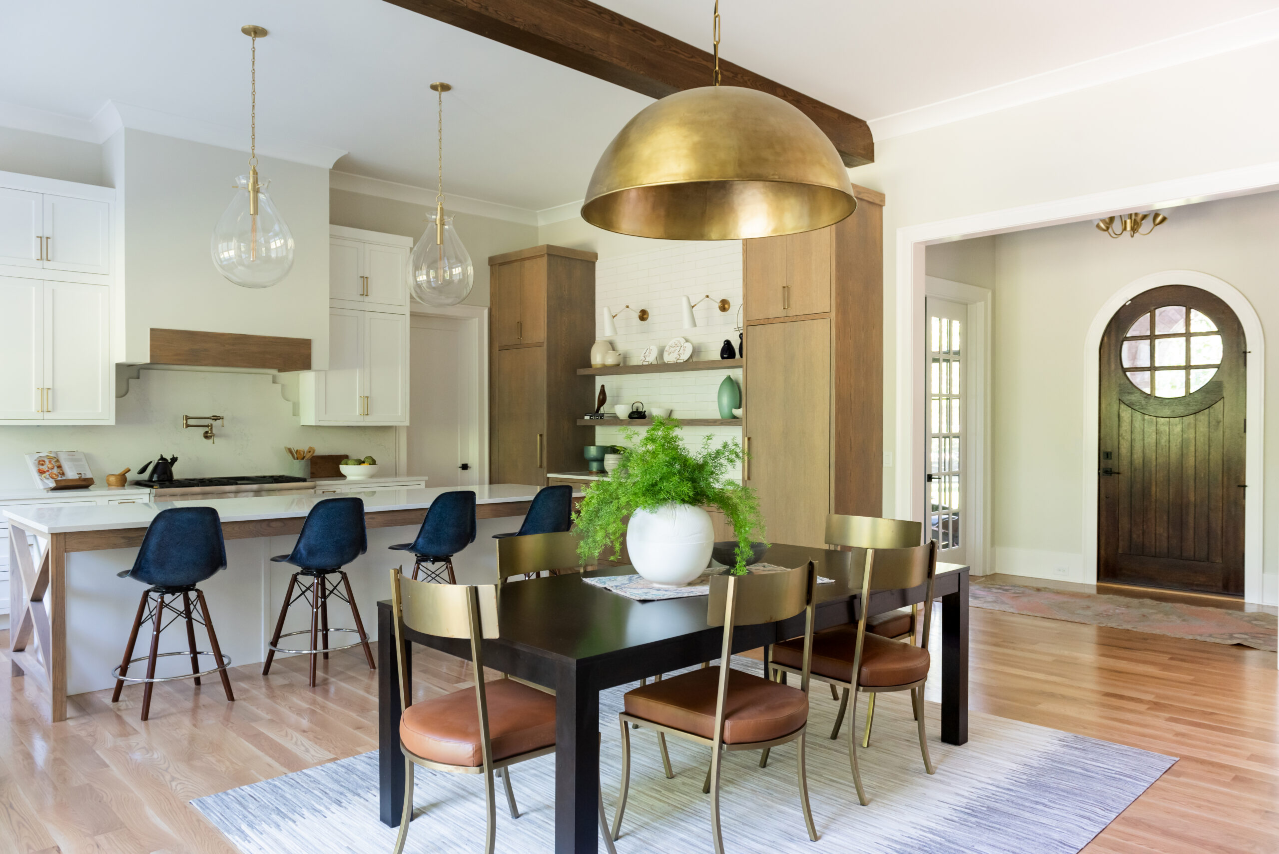 Dining table with gold plated dome chandelier and a view of the family room