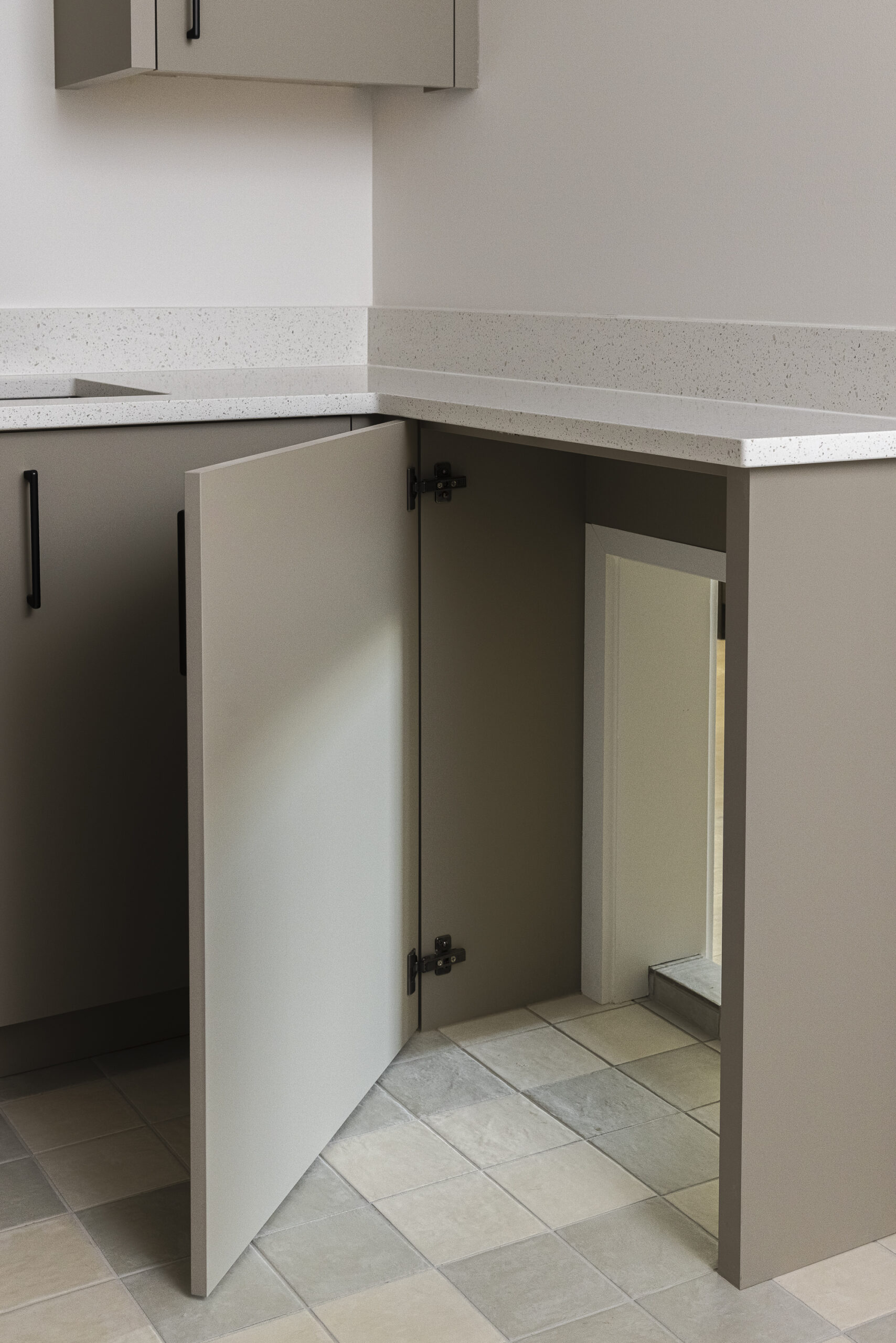 Checkered floor and built in cabinet door opening for passageway into the garage