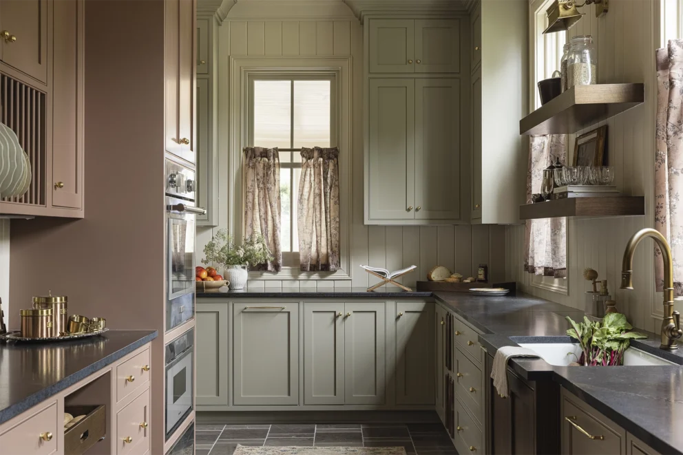 Kitchen with green and pink cabinets, gold hardware accents, and a tile floor