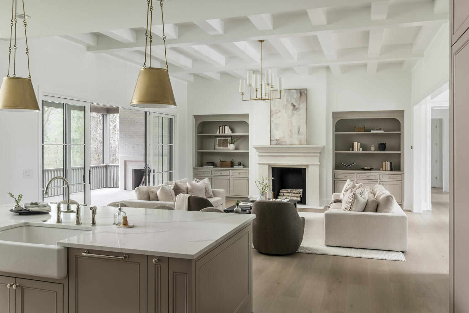 Creamy white walls with centered fireplace flanked with painted taupe built-in cabinetry with open shelving, a ceiling with painted beams